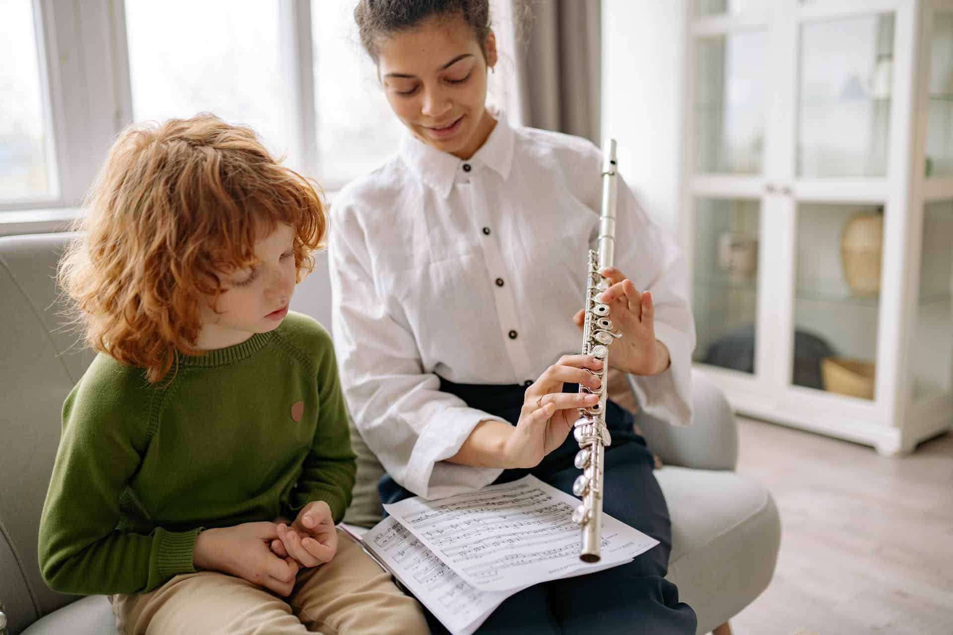 Vrouw leert muziekinstrument spelen aan kind